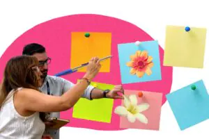 Two participants putting ideas on big post it notes with flowers in the foreground and a pink oval in the background
