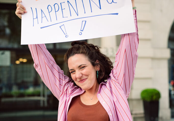 Jemima holding up a sign that says "Creativity is Happening"