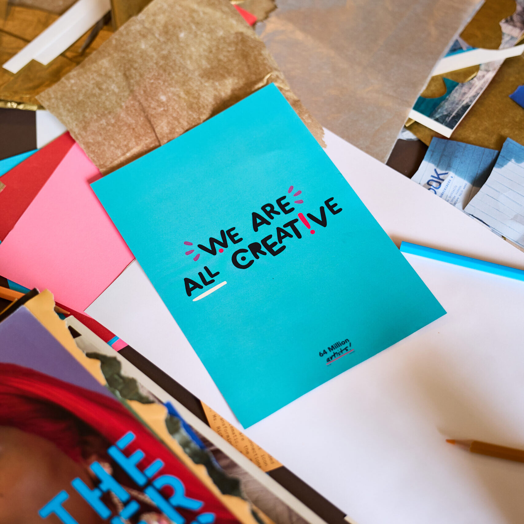 A photo of a blue flyer that reads 'We are all creative'